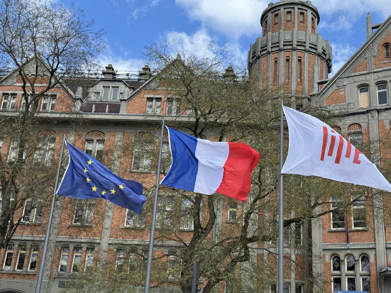 Drapeaux européen, français et de la Ville de Lille devant la façade arrière de la mairie de Lille